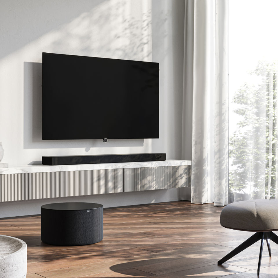 Loewe klang bar5 with sub5 – 5.1.2 Dolby Atmos home cinema setup in a white-beige designer living room with a Loewe TV